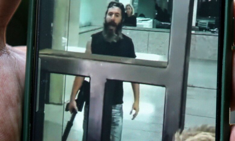 11 August 2022, Lebanon, Beirut: A man holding a smartphone shows a screen grab taken from a video of an armed depositor gesturing at employees of a local Bank in Beirut after he stormed the branch and held employees and customers as hostages. The man, who entered the bank carrying a machine gun and gasoline, demanded to be handed over part of his deposited money, which amounts to USD'209,000.