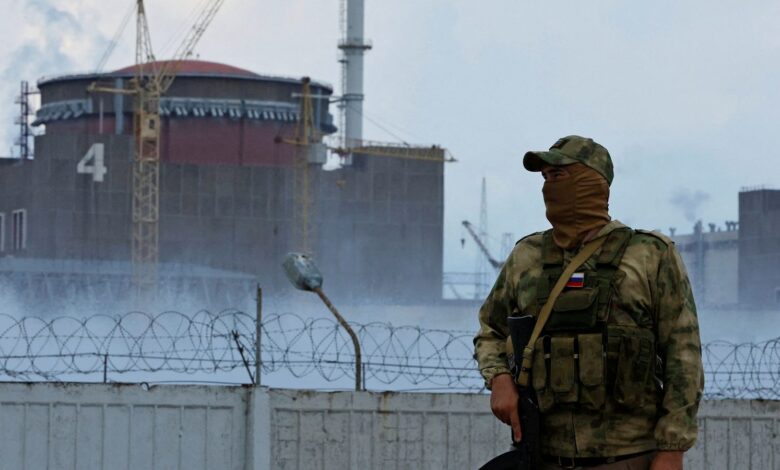 A serviceman with a Russian flag on his uniform stands guard near the Zaporizhzhia nuclear power plant on 4 August