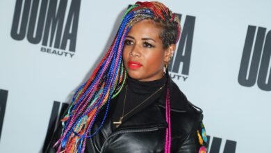 Kelis smiled shyly as two Asian women caressed her as she turned