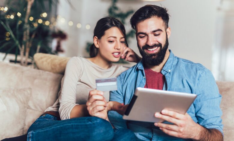 Couple using an iPad while holding a credit card