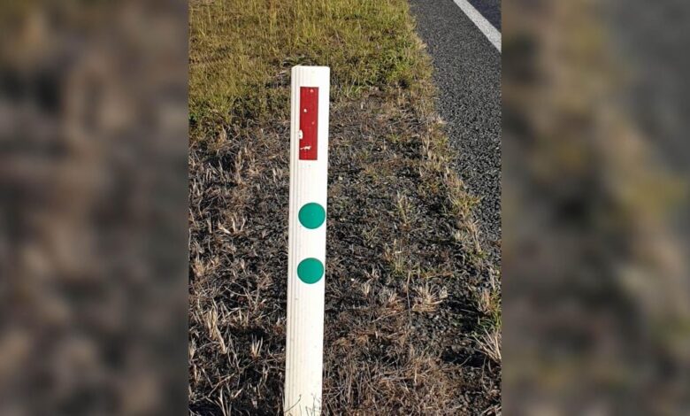 What do the green stickers on the roadside poles mean?