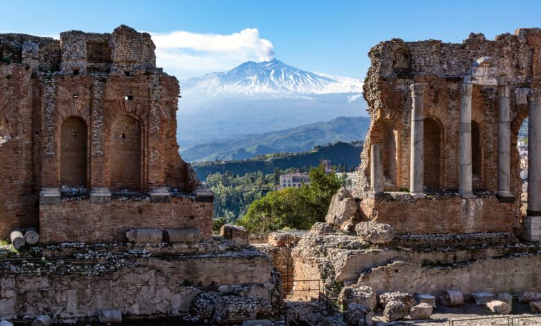 Volcano Etna in Sicily seen through ruins of ancient amphitheater in Taormina