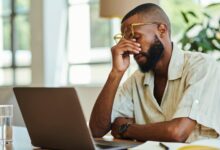 Young African man with laptop working indoors, home office concept. stock photo