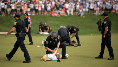 Protesters holding smoke bombs escape after disrupting the 72nd hole of the 2024 Travelers Championship